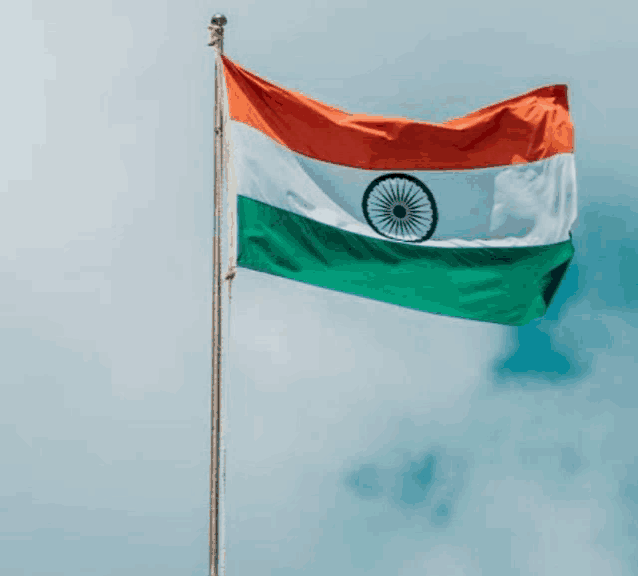 an indian flag is flying in the wind against a blue sky