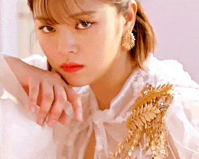 a close up of a woman 's face with her hand on her face