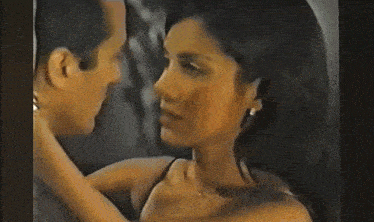 a man and a woman are kissing each other in a dark room .