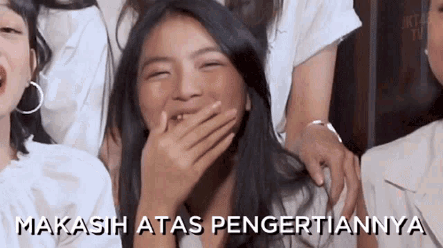 a girl is laughing with her hand over her mouth and the words " makasih atas pengertiannya " are written below her