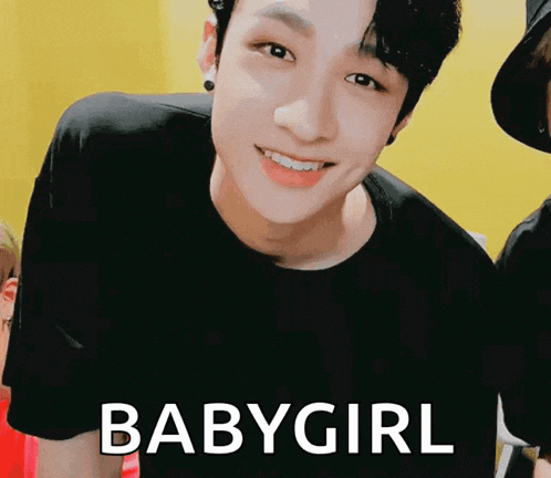 a young man wearing a black shirt is smiling with the words babygirl behind him