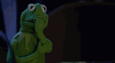 kermit the frog from the muppet show is holding his hand to his chin and thinking .