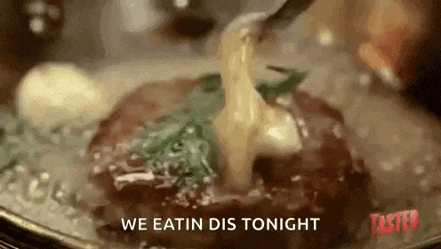 a close up of a steak being dipped in cheese with the words `` we eatin dis tonight '' .
