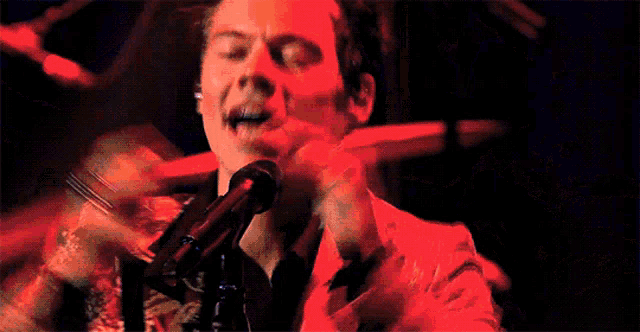 a man is singing into a microphone in a dark room .