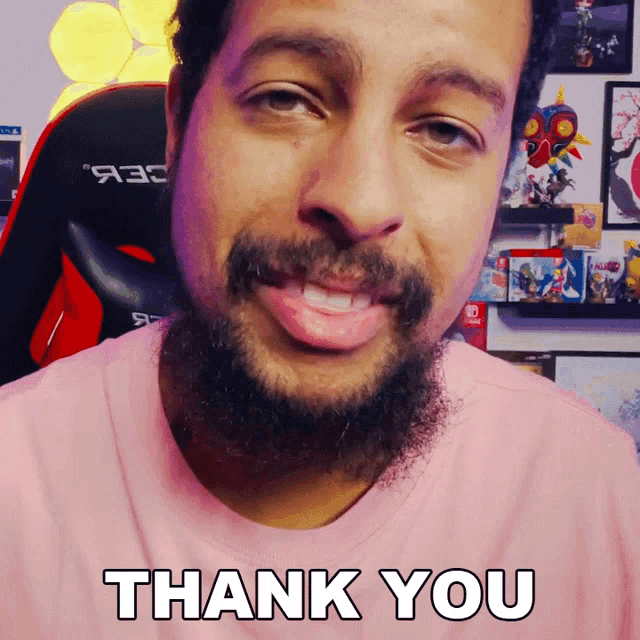 a man with a beard wears a pink shirt that says thank you