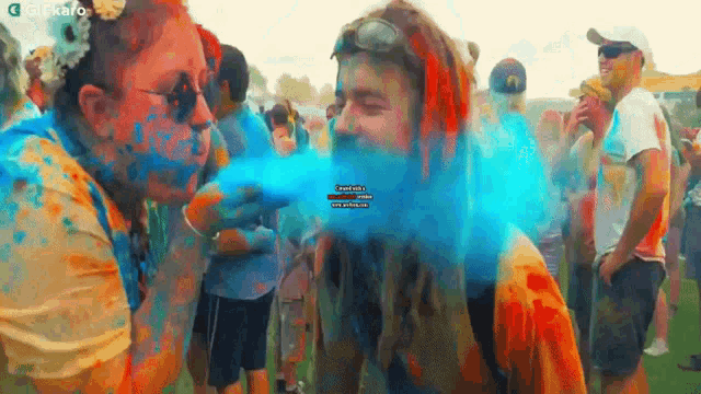 a group of people are covered in colored powder including a man and woman