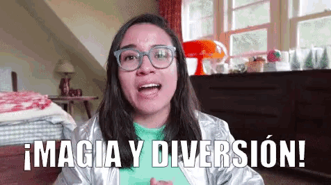 a woman wearing glasses and a silver jacket says " magia y diversion "