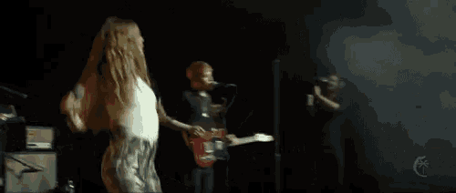 a man playing a guitar and a woman singing on a stage