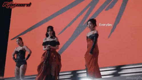 three women in red dresses are standing in front of a screen that says everyday