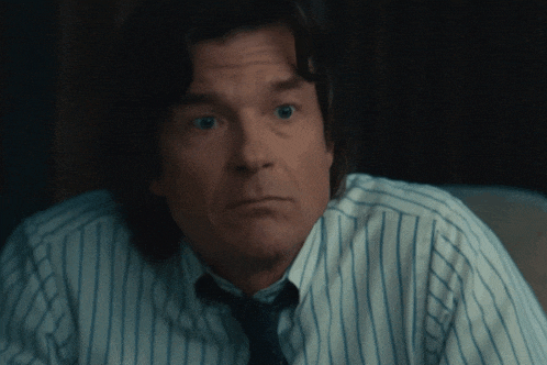 a man wearing a striped shirt and tie looks very surprised
