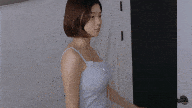 a woman in a blue tank top is standing in front of a door that says usa