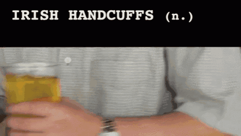 a man is holding a glass of beer with the words irish handcuffs written on the bottom