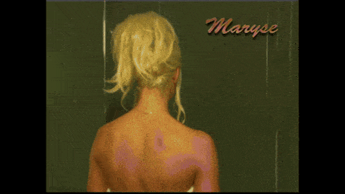 a woman with blonde hair is standing in front of a sign that says maryse