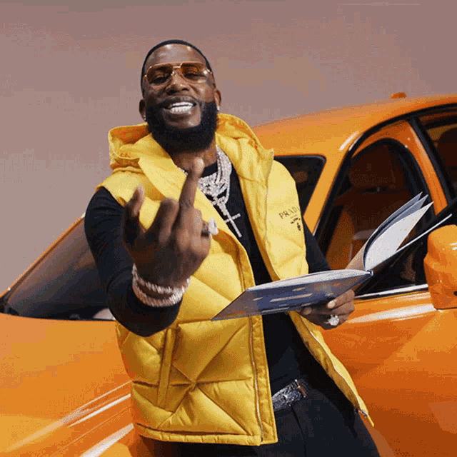a man wearing a yellow vest that says prada giving the middle finger