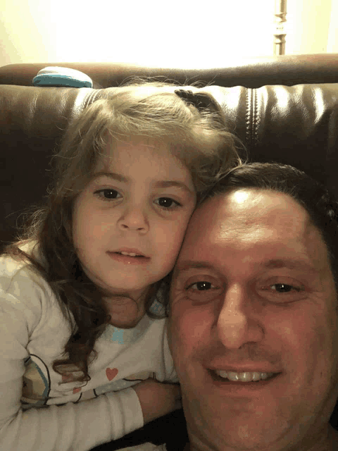 a man and a little girl are posing for a picture together