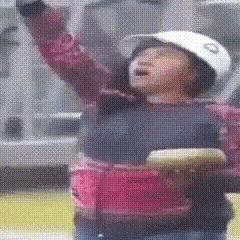 a person wearing a white helmet and a pink shirt is holding a frisbee in their hand .