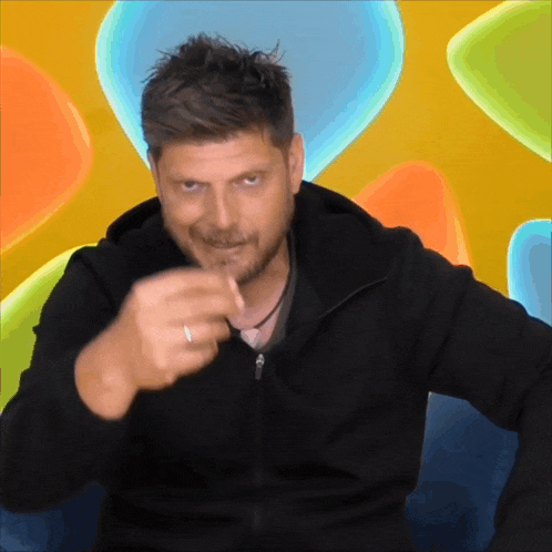 a man in a black jacket is pointing his finger