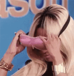 a woman covering her eyes with a pink purse .