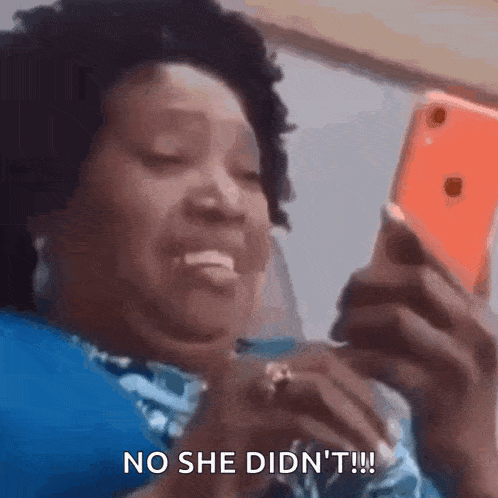 a woman is laughing while looking at her cell phone and saying no she didn 't .
