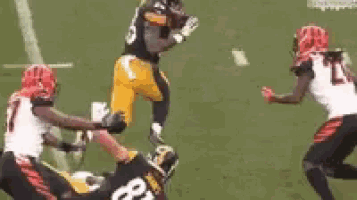 a group of football players are playing a game on a field . one of the players has the number 21 on his jersey .