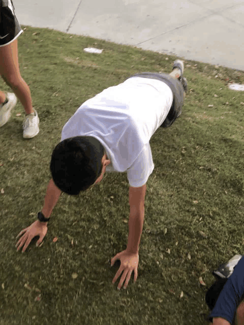 a man is doing push ups in the grass