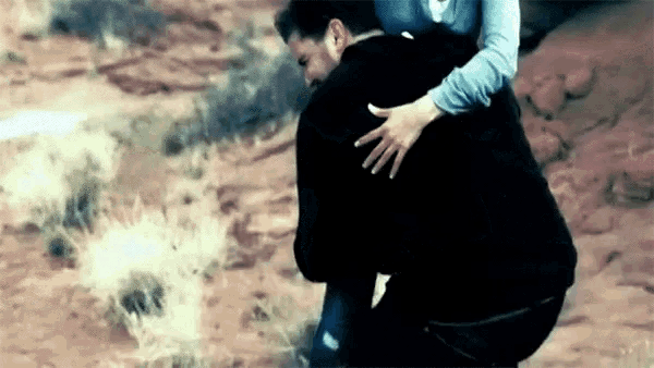 a man is being lifted up by a woman in a field