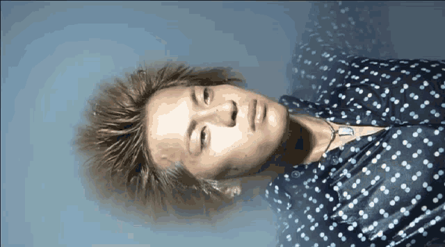 a man wearing a polka dot shirt is laying down