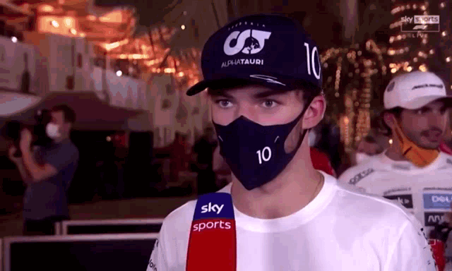 a man wearing a face mask and a hat with the number 10 on it .