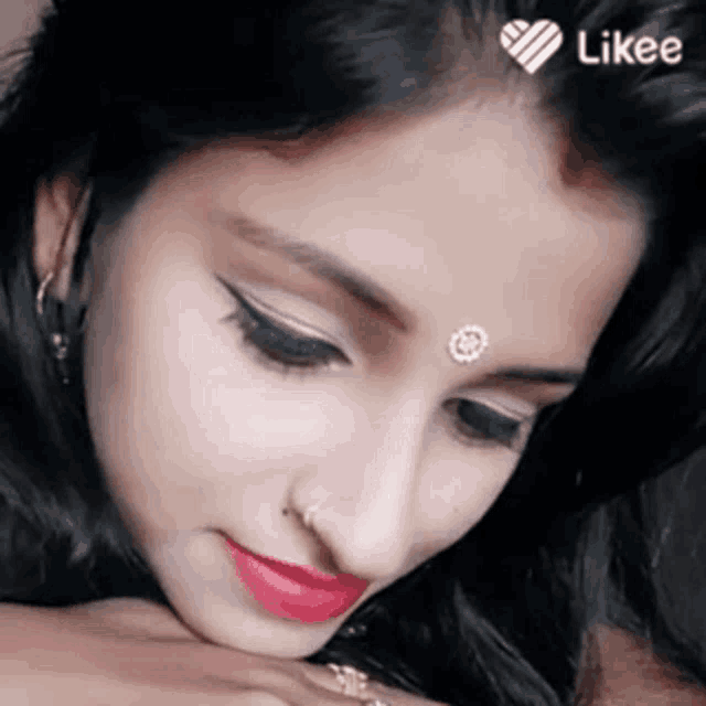 a close up of a woman 's face with a bindi on her forehead