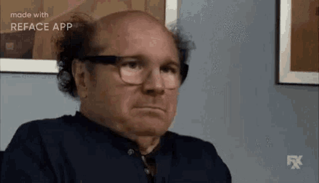 a bald man wearing glasses and a black shirt is making a funny face .