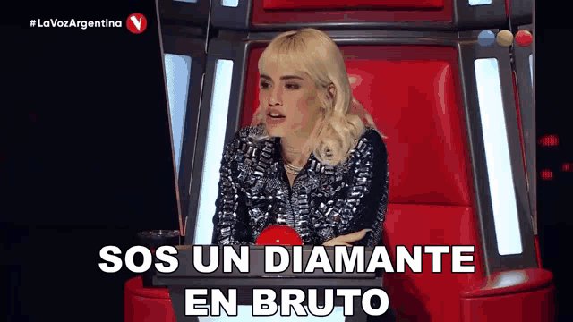 a woman sitting in a chair with the words sos un diamante en bruto written on the screen