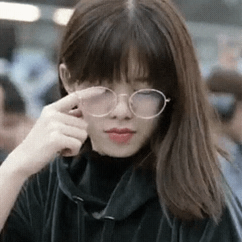 a close up of a woman wearing glasses and a black turtleneck .