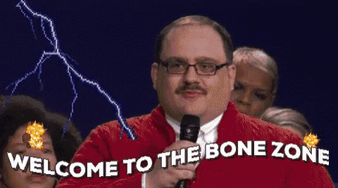 a man with glasses and a mustache is holding a microphone and saying welcome to the bone zone