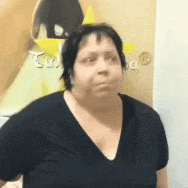 a woman in a black shirt is looking at the camera .