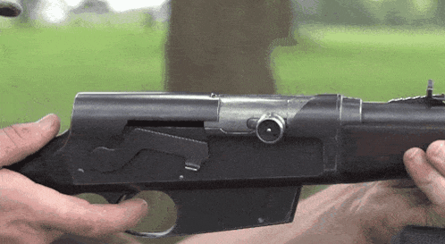 a person is holding a shotgun in their hands
