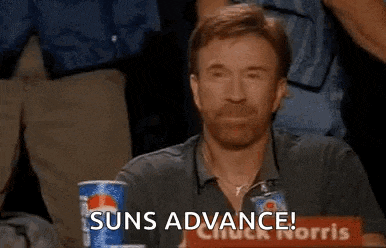 a man with a beard is sitting at a table with a pepsi can and a sign that says suns advance .
