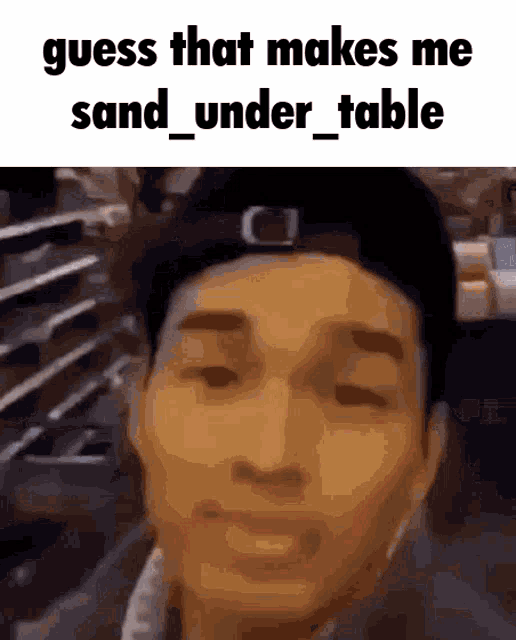 a man wearing a hat with the words guess that makes me sand under table on the top