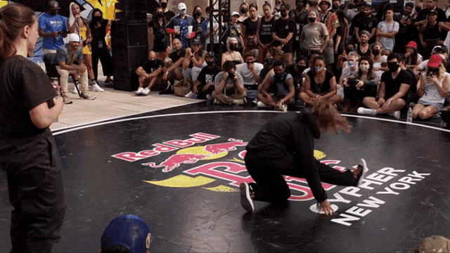a woman is kneeling on a mat that says red bull