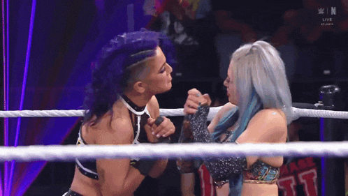 two women are wrestling in a ring with a sign that says chase on it