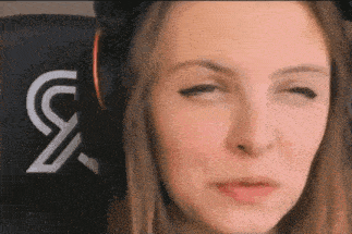 a close up of a woman making a funny face while wearing headphones .