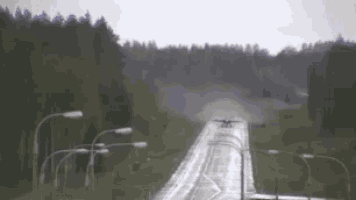 a blurred image of a highway with trees on the side of it