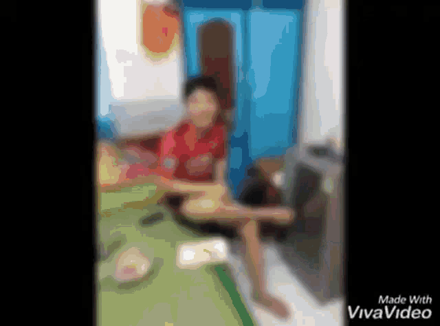a blurry picture of a person sitting on a bed in a living room .