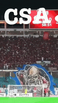 a soccer field with a large iron maiden mural on the side