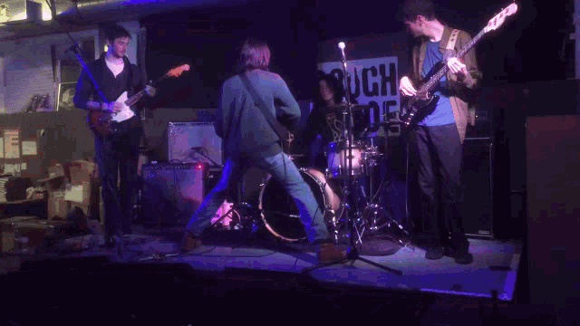 a group of people playing instruments in front of a sign that says rough trades