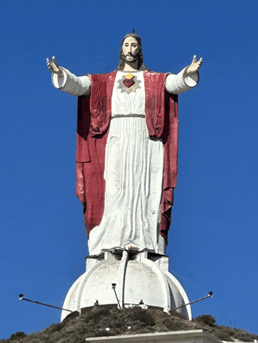 a statue of jesus with his arms outstretched and a heart on his chest