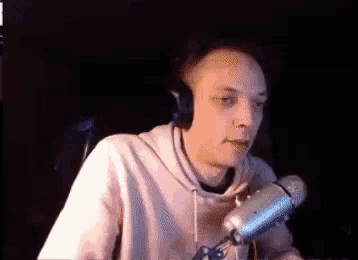 a man is sitting in front of a microphone wearing headphones .