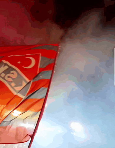 a red and orange flag with a crescent moon and the word yea on it