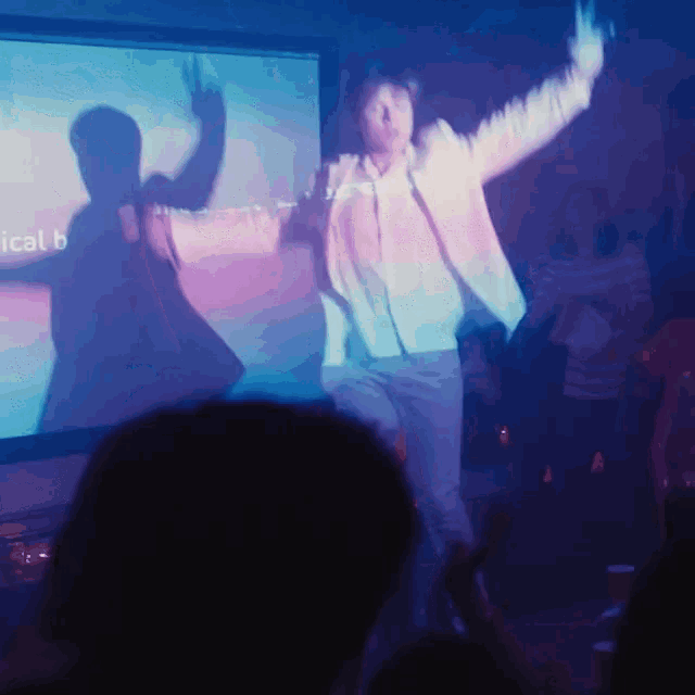 a man dancing in front of a screen that says ical b