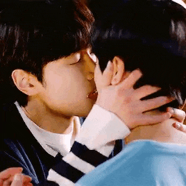 a couple of men are kissing each other in a close up .