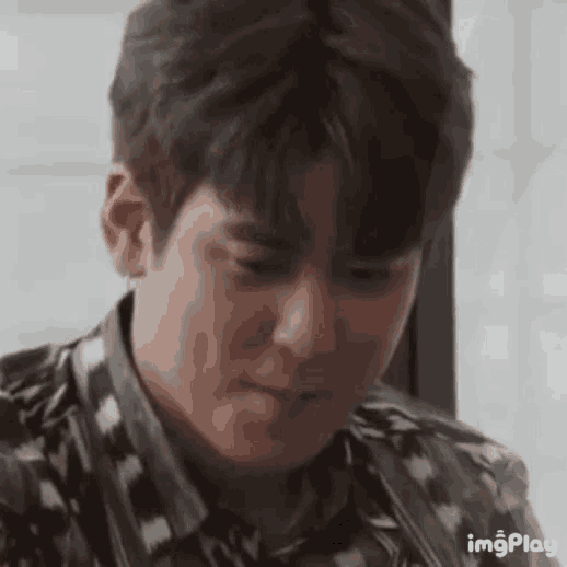 a close up of a young man 's face with a slight smile on his face .